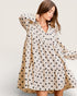 Woman wearing a polka dot dress against a plain background