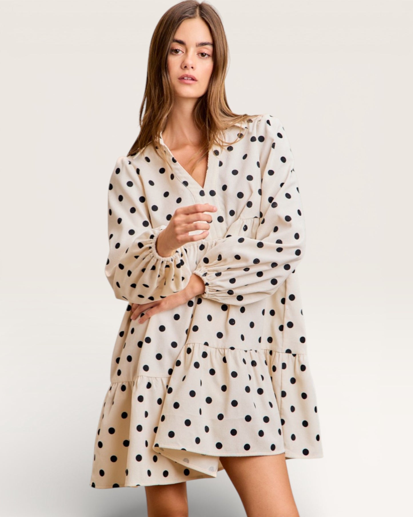 Woman wearing a polka dot dress on a plain background