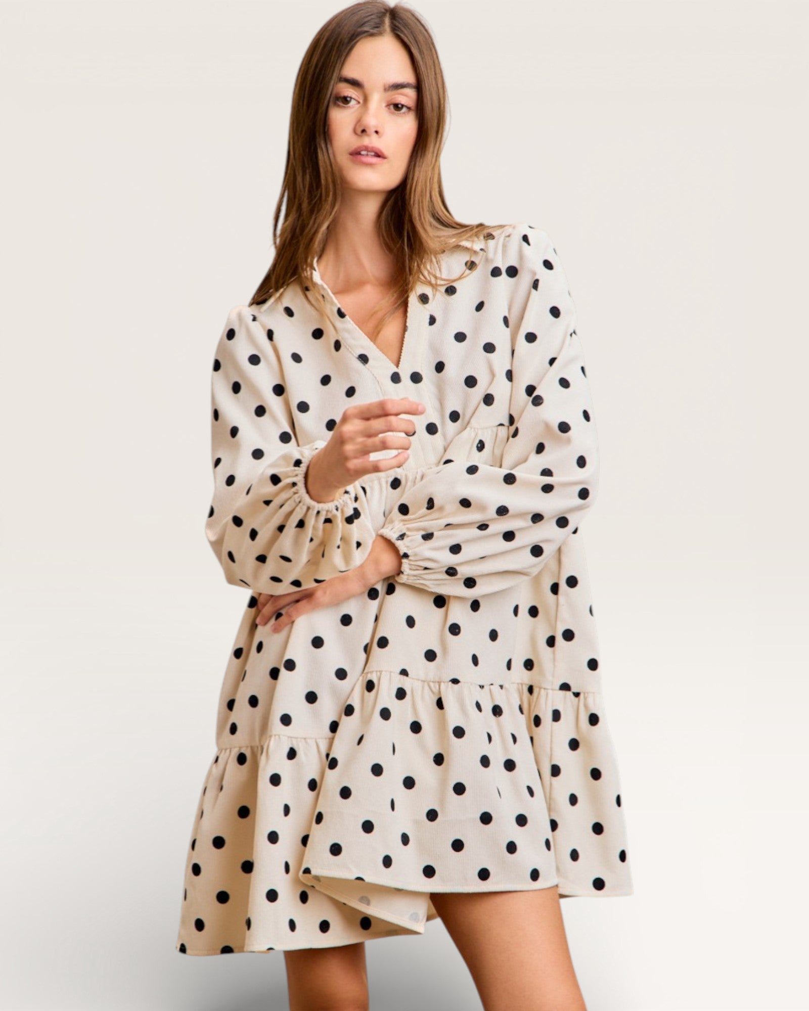 Woman wearing a polka dot dress on a plain background
