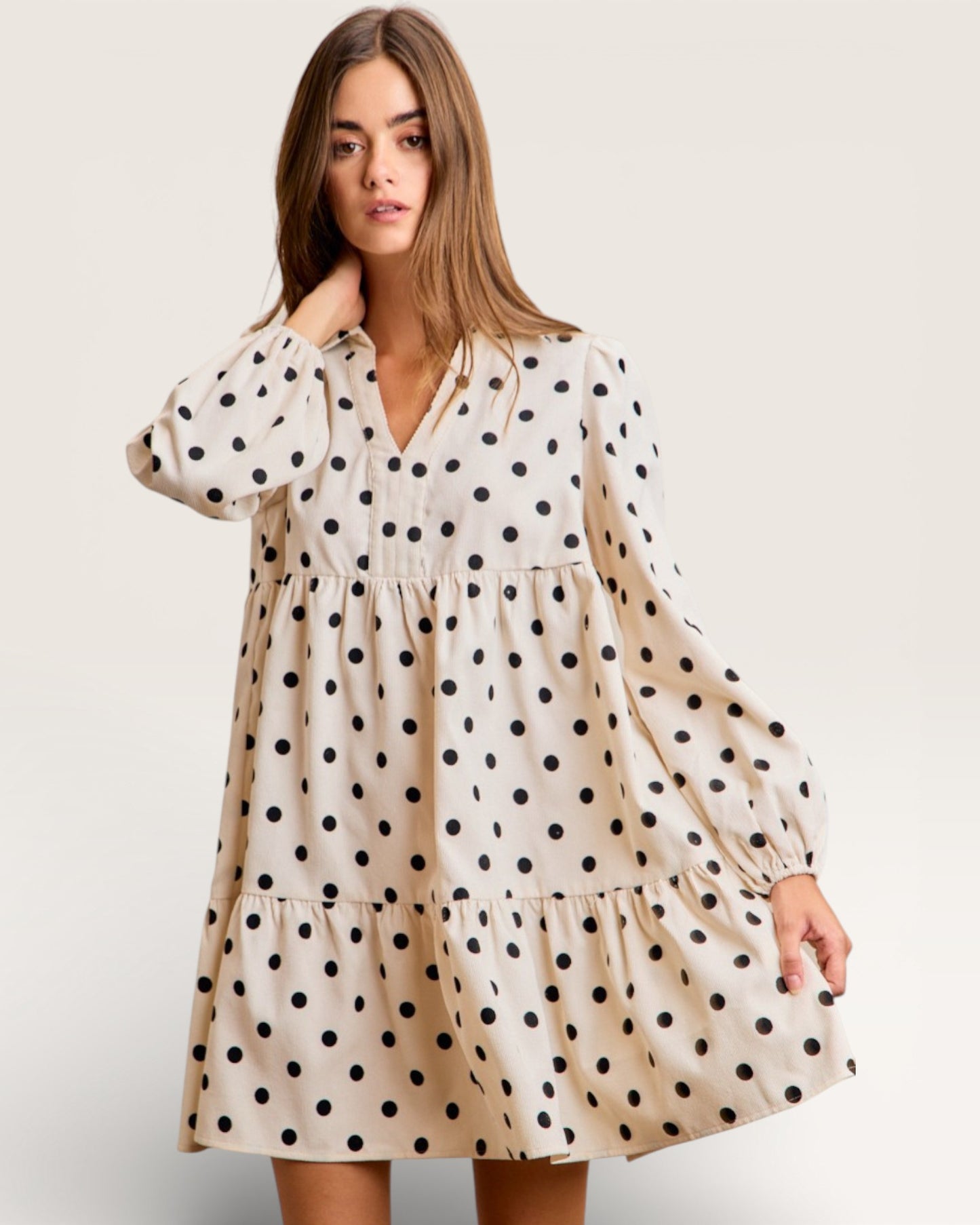 Woman wearing a polka dot dress on a plain background