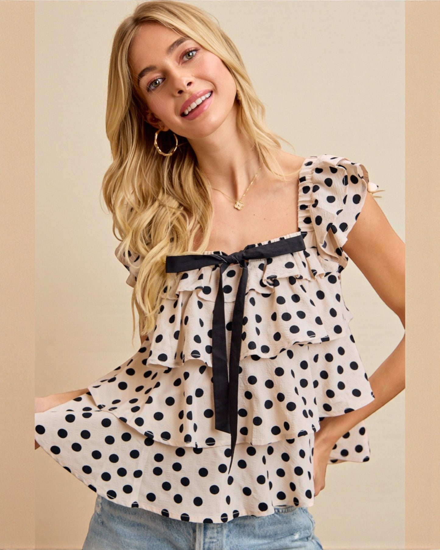 Woman wearing a polka dot blouse with a beige background