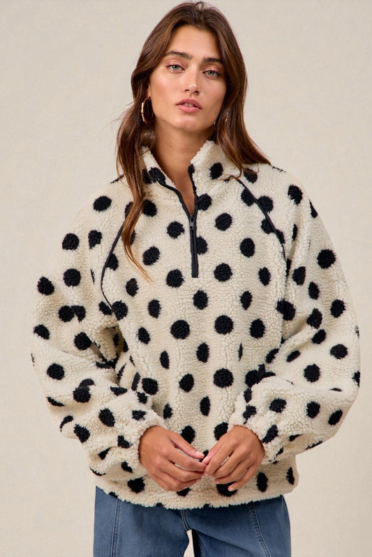 Woman wearing a polka dot fleece pullover against a neutral background