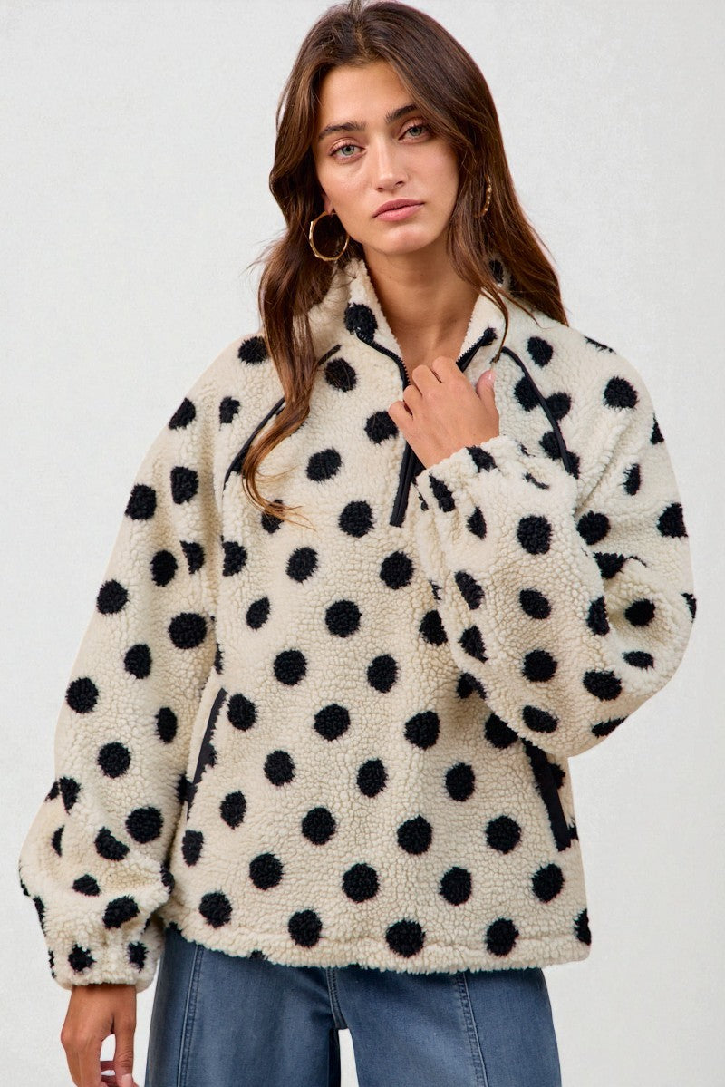 Woman wearing a polka dot fleece jacket against a white background