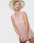 Woman wearing a pink sleeveless top and beige hat on a white background