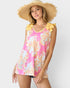 Woman wearing a floral top with yellow ruffled sleeves and a straw hat on a white background