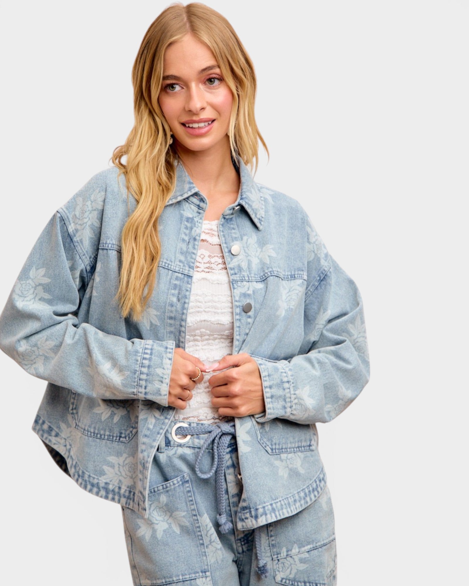 Woman wearing a light blue denim jacket on a white background