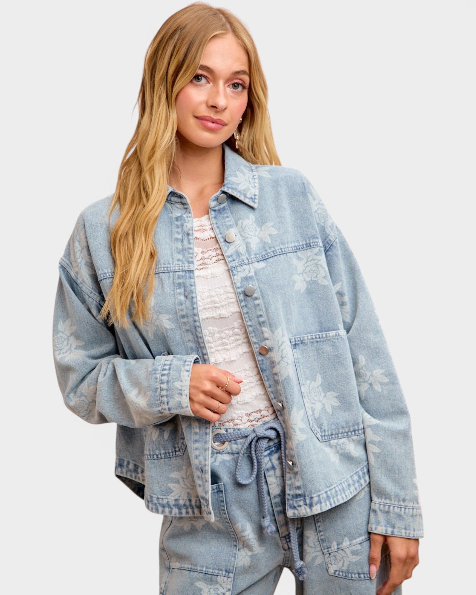 Woman wearing a light blue denim jacket on a plain background