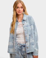 Woman wearing a light blue denim jacket on a white background