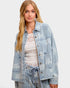 Woman wearing a light blue denim jacket on a white background