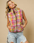 Woman wearing a colorful quilted vest against a beige background