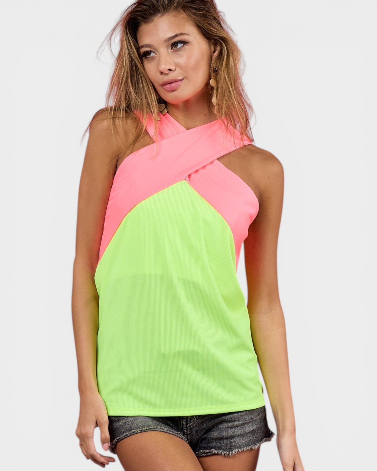 Woman wearing a neon green and pink top on a white background