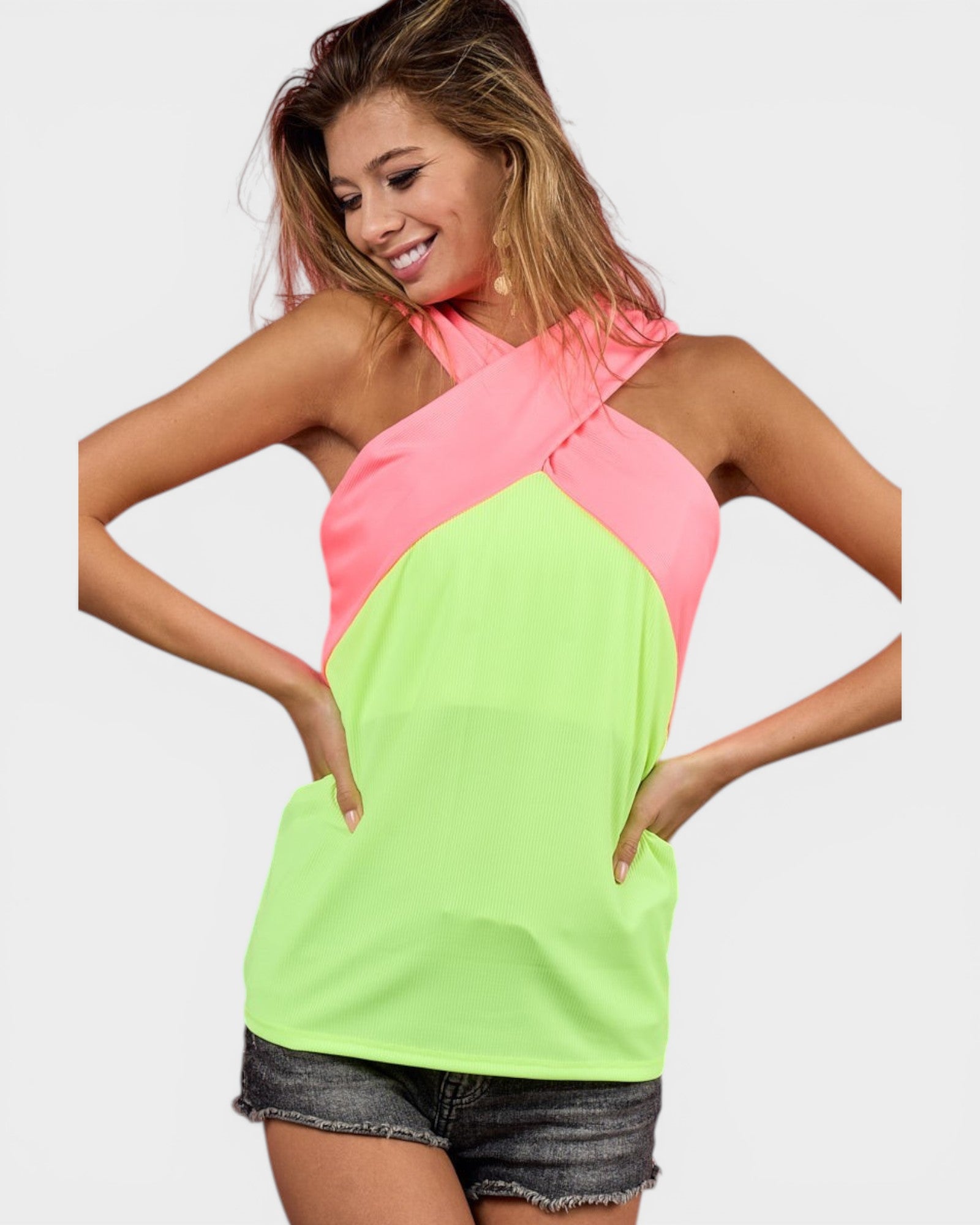 Woman wearing a neon green and pink halter top on a white background