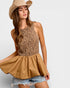 Woman wearing a leopard print top and beige skirt with a wide-brimmed hat on a white background