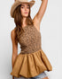 Woman wearing a leopard print top and beige hat against a white background