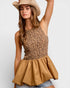 Woman wearing a leopard print top and beige hat on a white background
