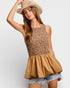 Woman wearing a leopard print top and beige hat on a white background