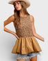 Woman wearing a leopard print top and beige skirt with a plain background