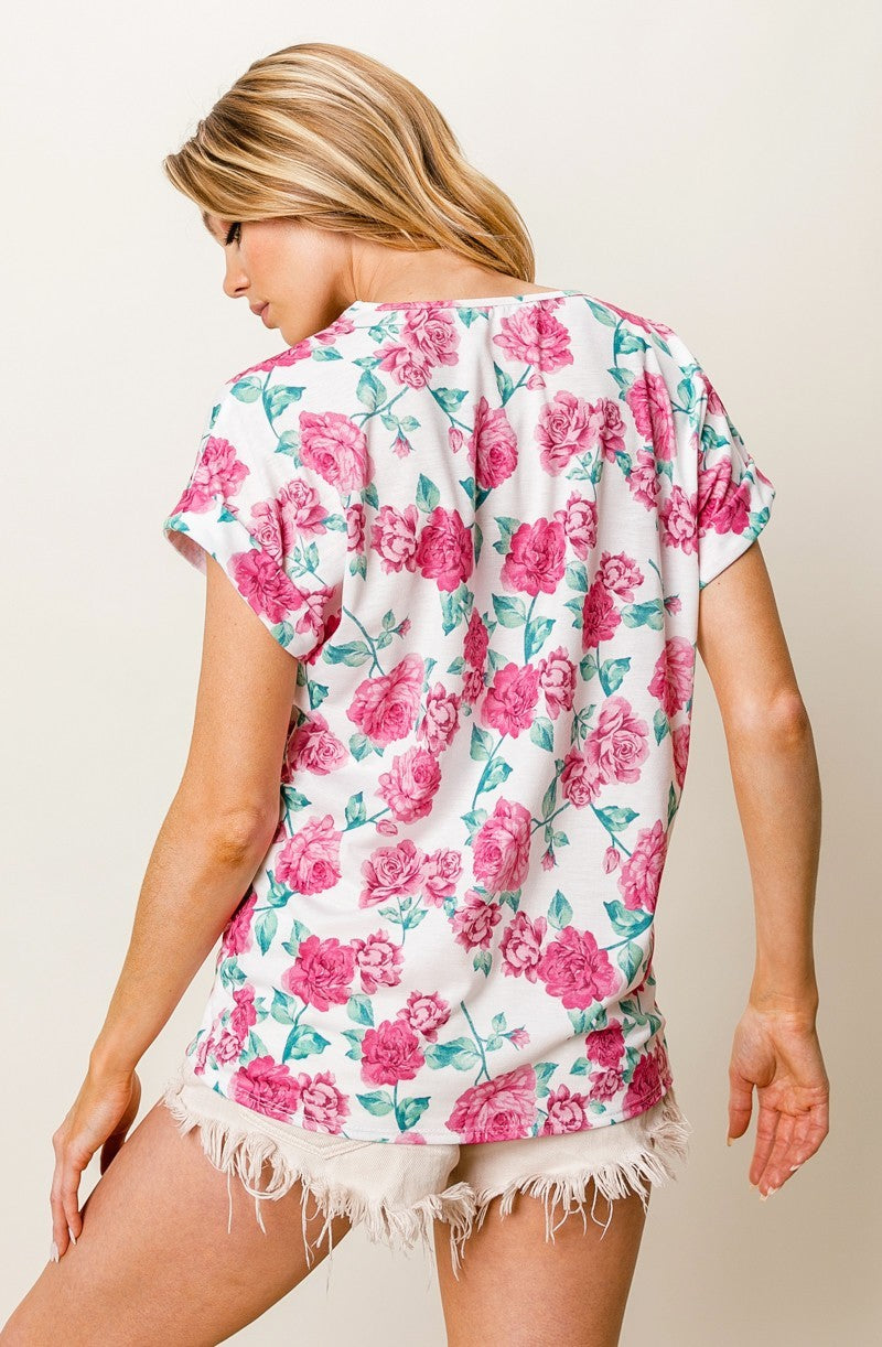 Woman wearing a floral top with pink roses on a white background