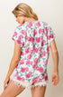 Woman wearing a floral top with pink roses on a white background