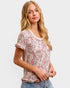 Woman wearing a floral blouse with ruffled sleeves on a white background