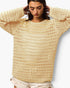 A woman wearing a cream-colored, open-knit crewneck sweater with textured horizontal rows, paired with light beige shorts, against a plain white background.