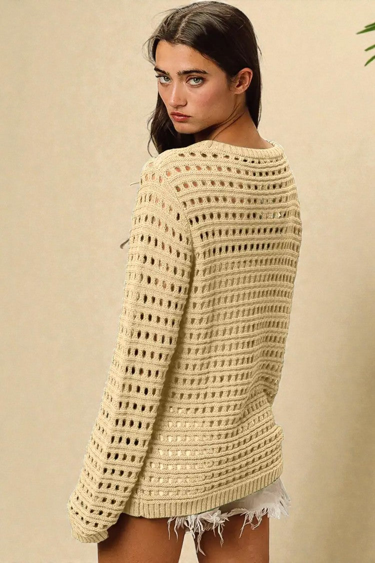 Woman wearing a beige crochet sweater against a beige background