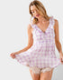 Woman wearing a purple and white checkered dress on a plain background