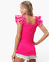 A woman shown from the back wearing a bright pink ribbed top with dramatic ruffled shoulder details and white denim shorts against a plain white studio background.