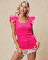 Woman wearing a bright pink top with ruffled sleeves on a beige background