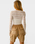 Person wearing a patterned long-sleeve top and beige cargo shorts on a white background