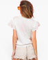 A woman shown from behind wearing a white short-sleeve t-shirt with ruffled sleeves and light beige distressed denim shorts, set against a plain white background.
