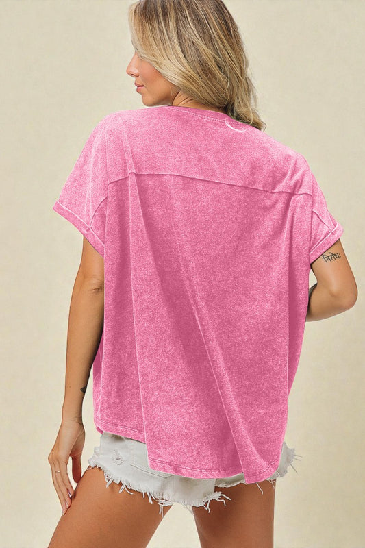 Woman wearing a pink oversized shirt and white shorts on a beige background