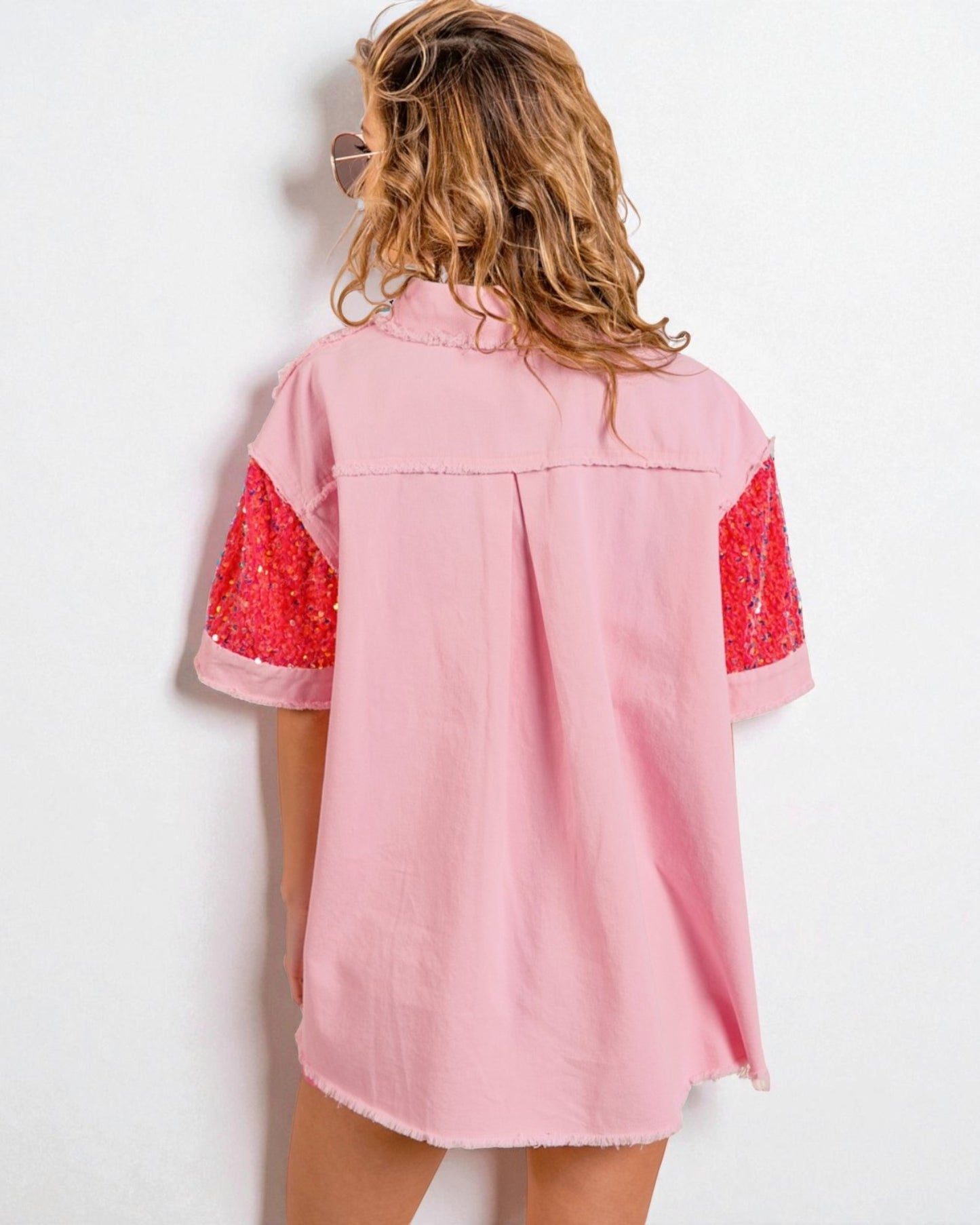 Pink dress with red lace sleeves worn by a person on a white background
