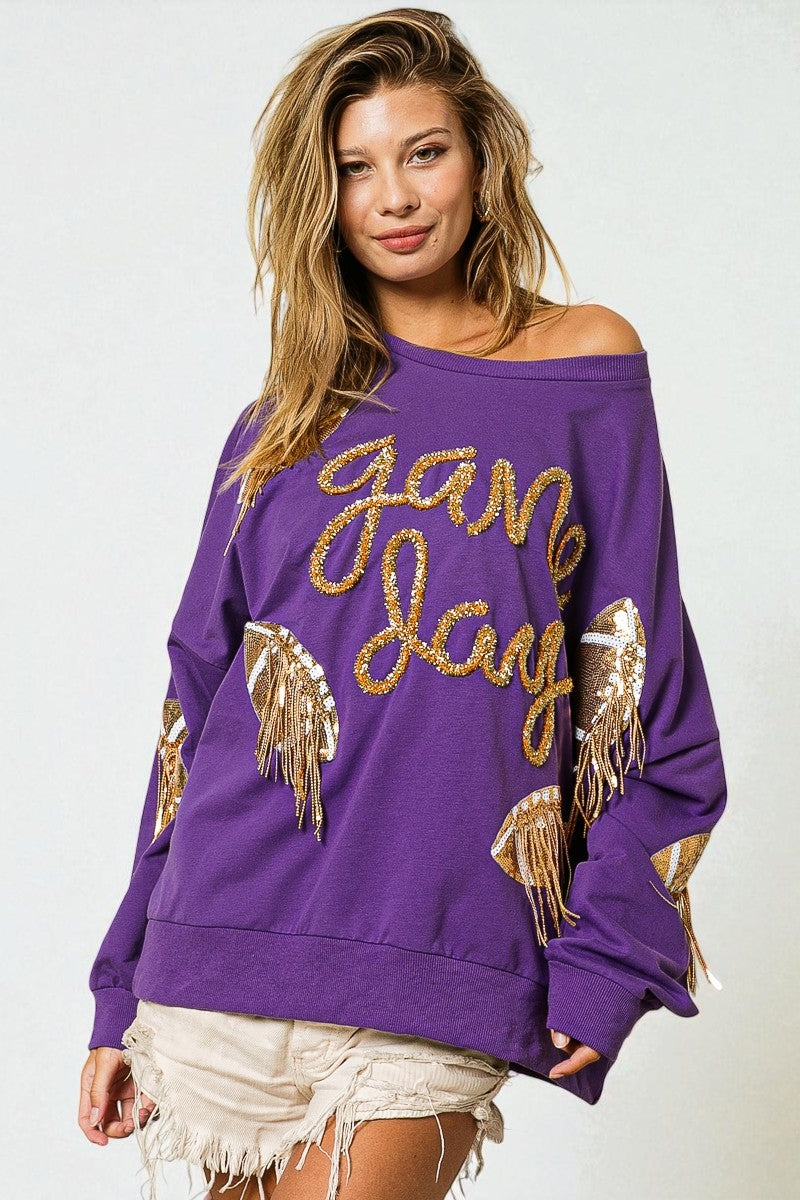 Woman wearing a purple sweatshirt with gold text and designs on a white background