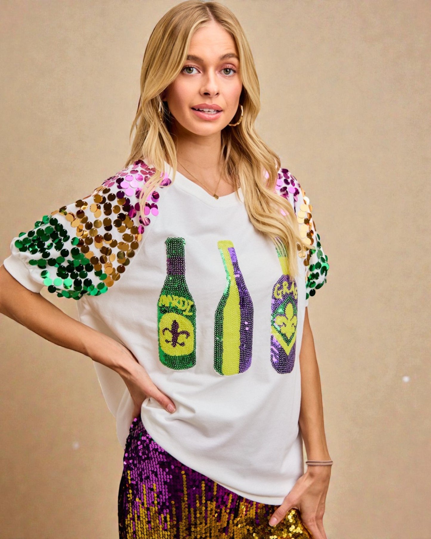 Woman wearing a white t-shirt with colorful sequin designs on a beige background