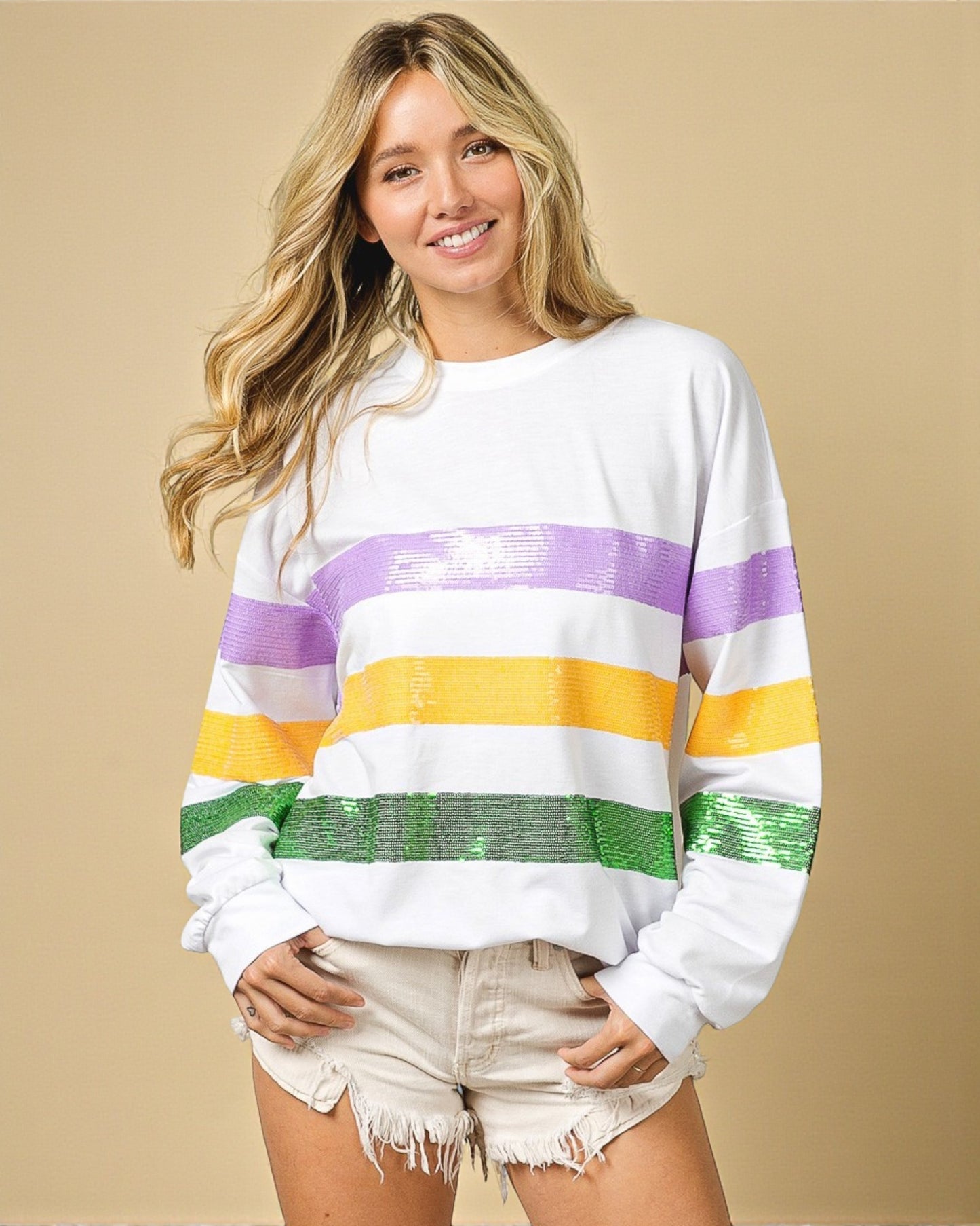 Woman wearing a colorful striped sweater against a beige background