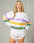 Woman wearing a white long-sleeve shirt with colorful stripes against a neutral background