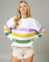 Woman wearing a white sweatshirt with colorful stripes on a gray background