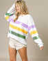 Woman wearing a colorful striped sweater and shorts on a beige background