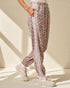 Leopard print jogger pants with white stripes worn by a person on a neutral background