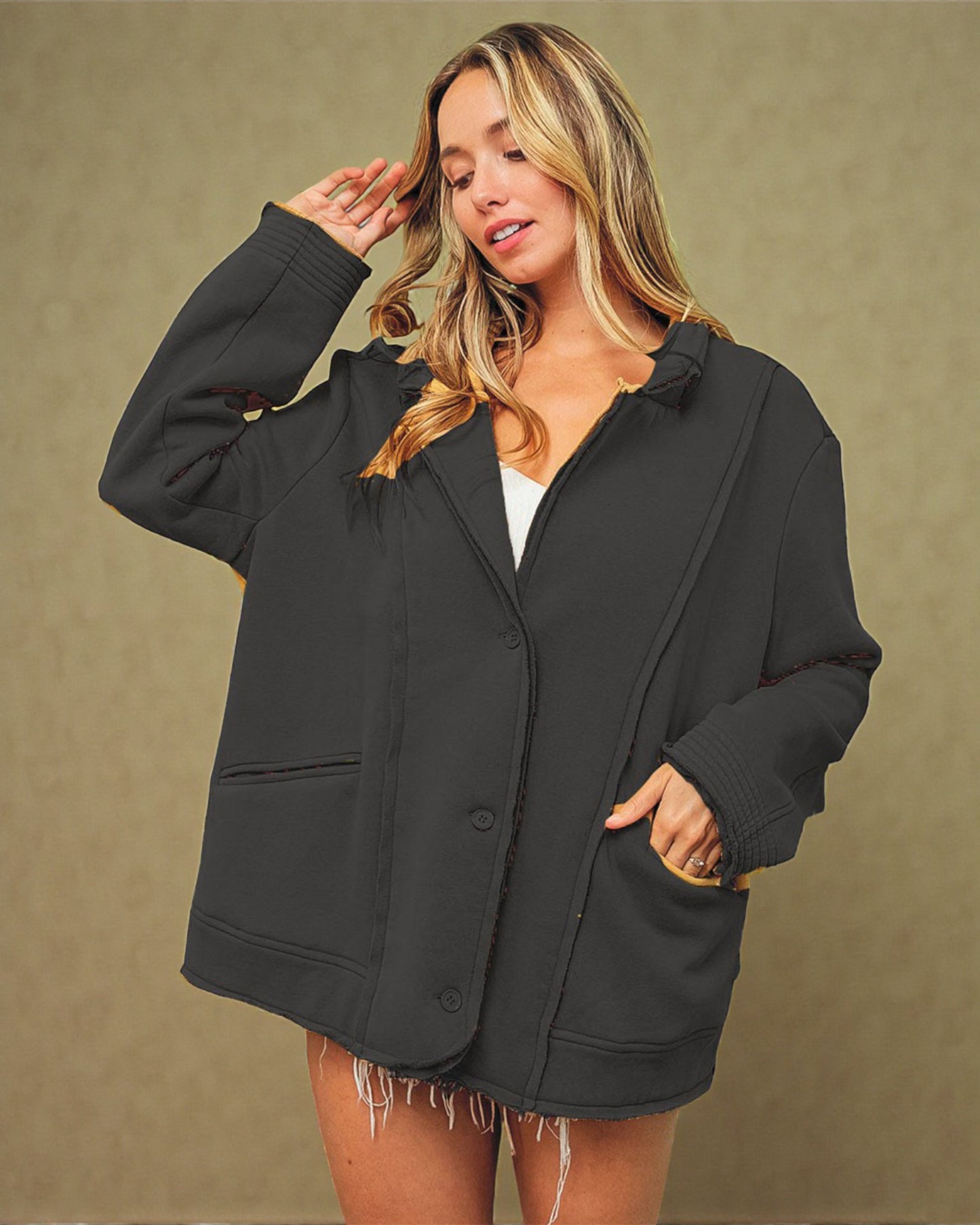 Woman wearing a black jacket against a beige background