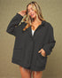 Woman wearing a black jacket against a beige background