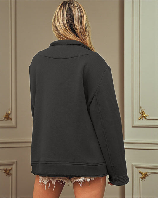 Person wearing a black jacket in front of a neutral-colored wall with gold handles.