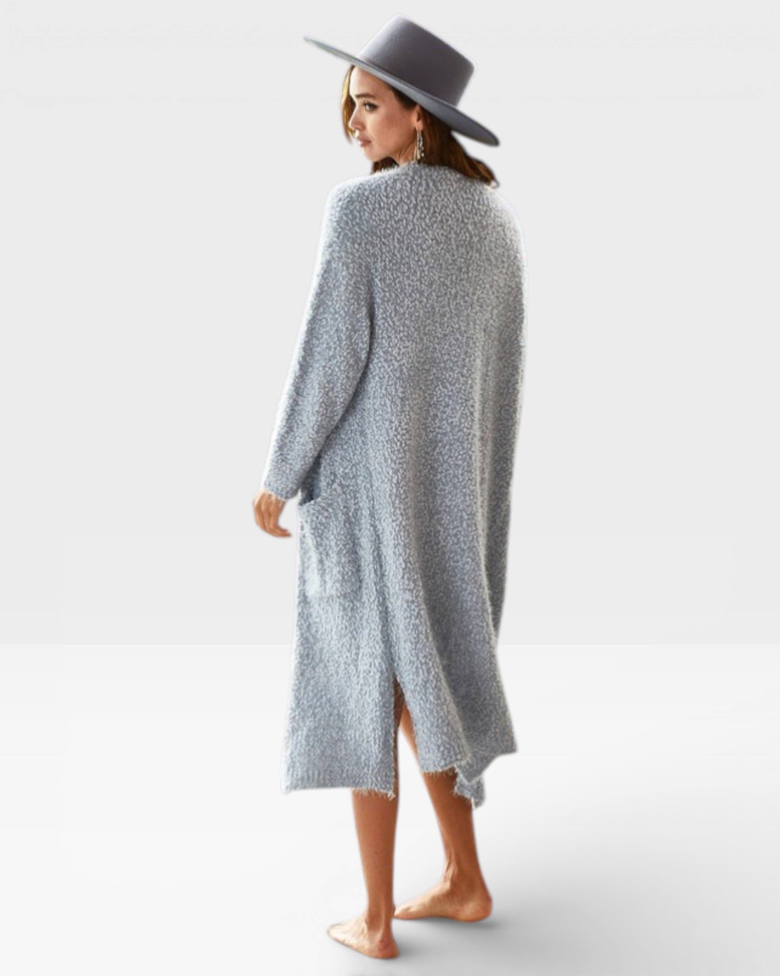 Woman wearing a long, light gray cardigan and a gray hat on a white background