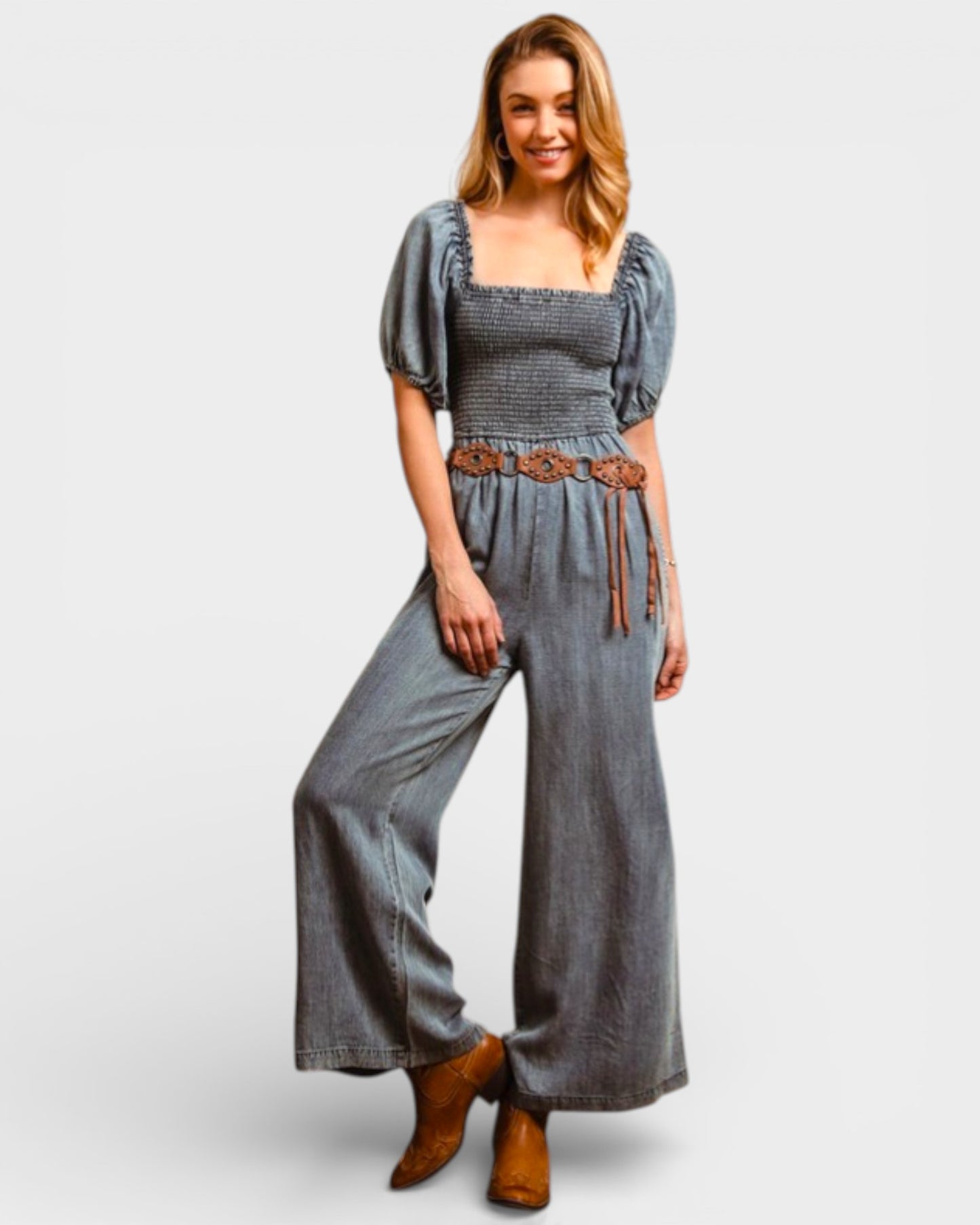 Woman wearing a denim jumpsuit with puff sleeves on a white background