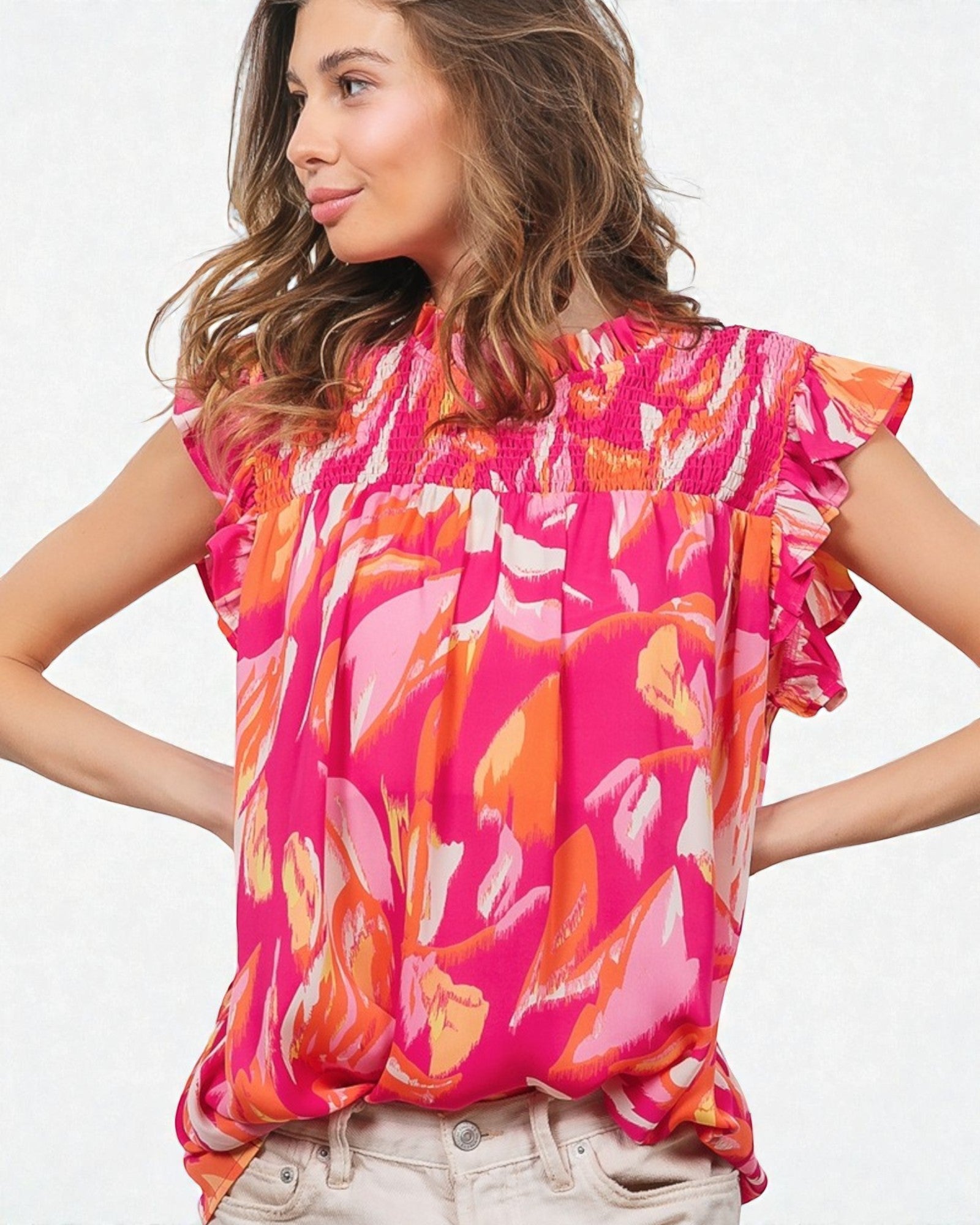 Woman wearing a colorful floral blouse with a plain background