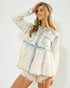 Woman wearing a white denim shirt with blue stitching on a plain background