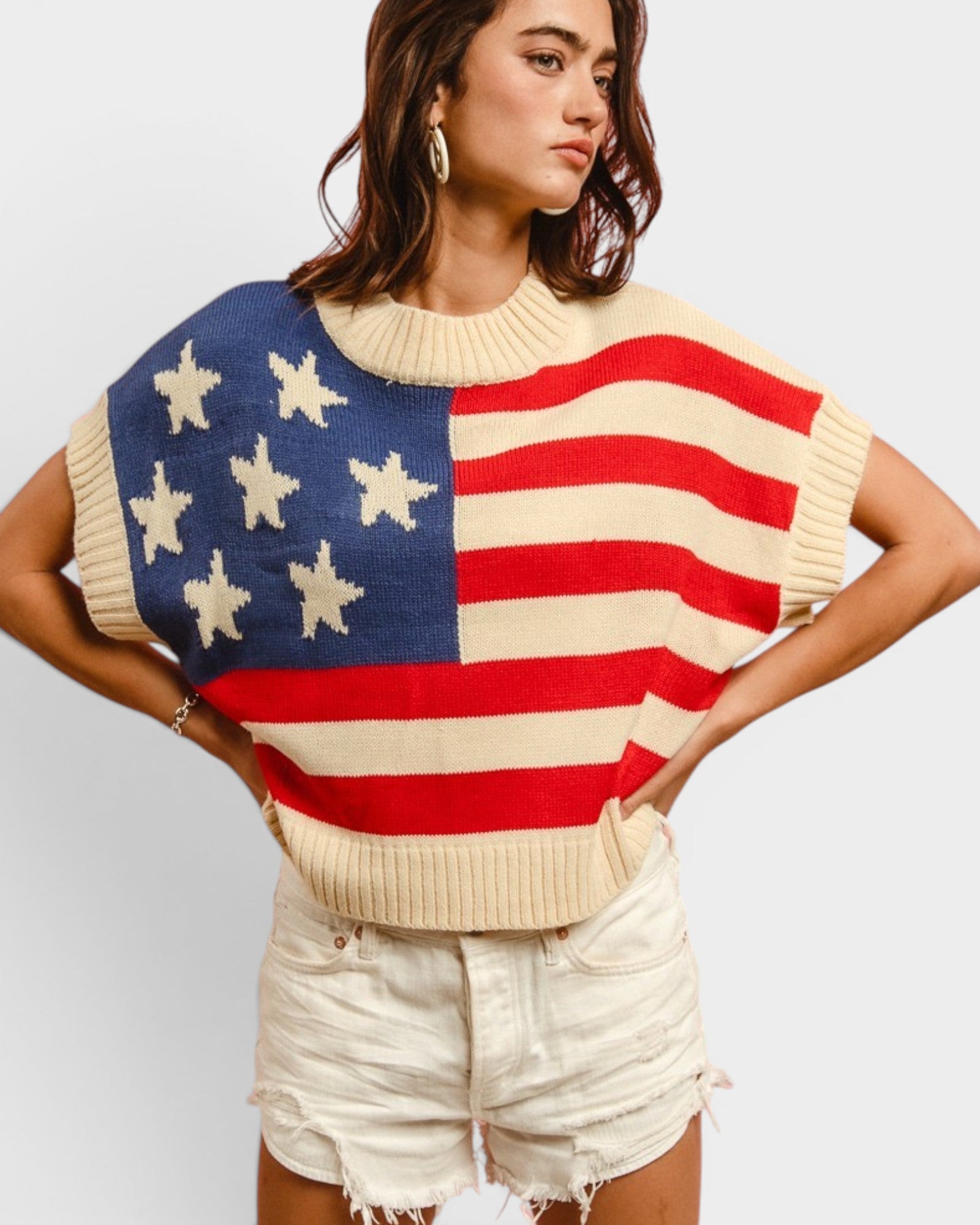 Person wearing a sweater with an American flag design on a plain background