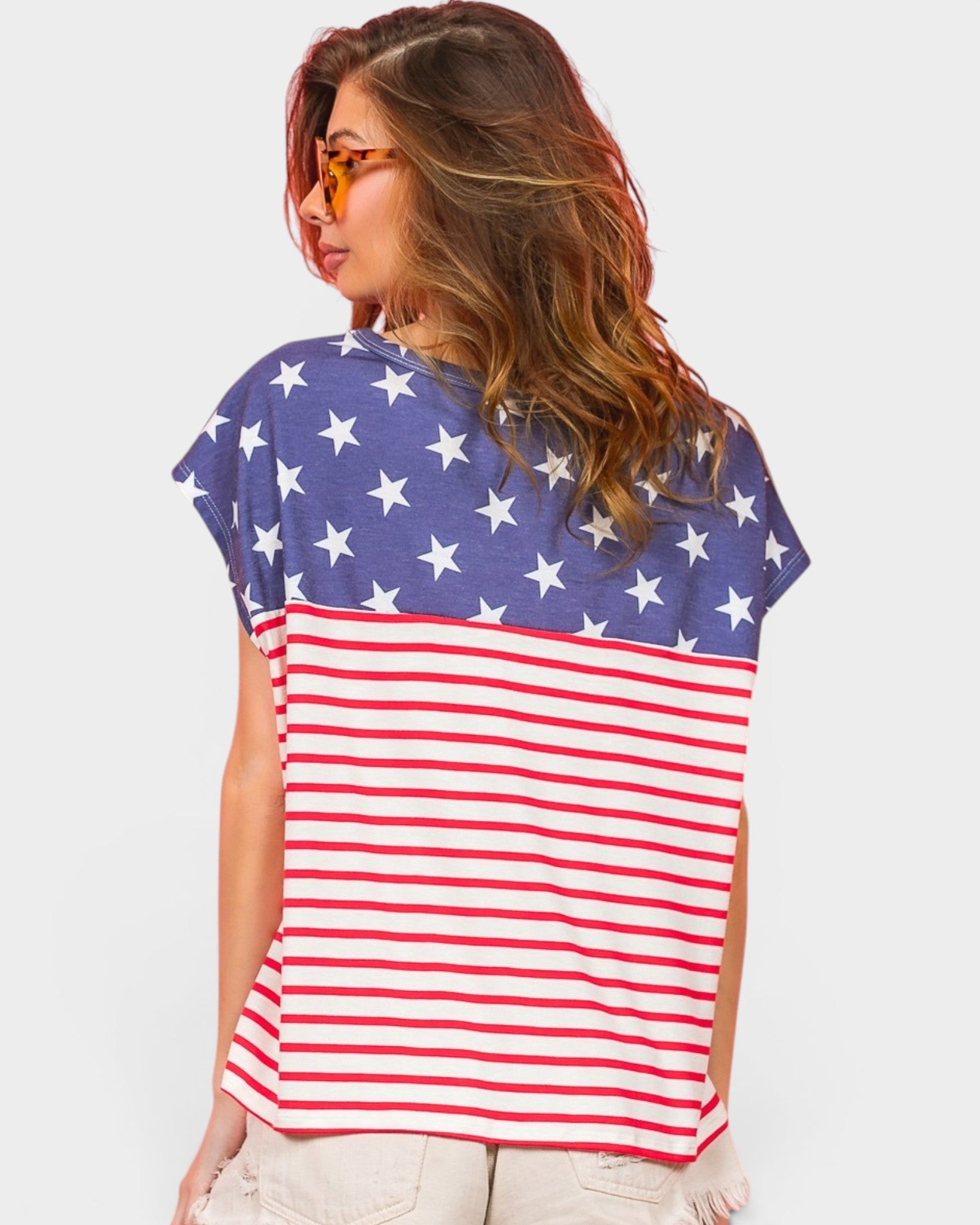 Woman wearing a t-shirt with an American flag design on a plain background