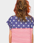 Person wearing a shirt with American flag design on a plain background